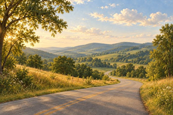 An open road through green hills